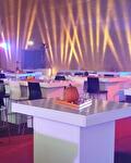 Feestzaal met witte statafels en sfeerverlichting